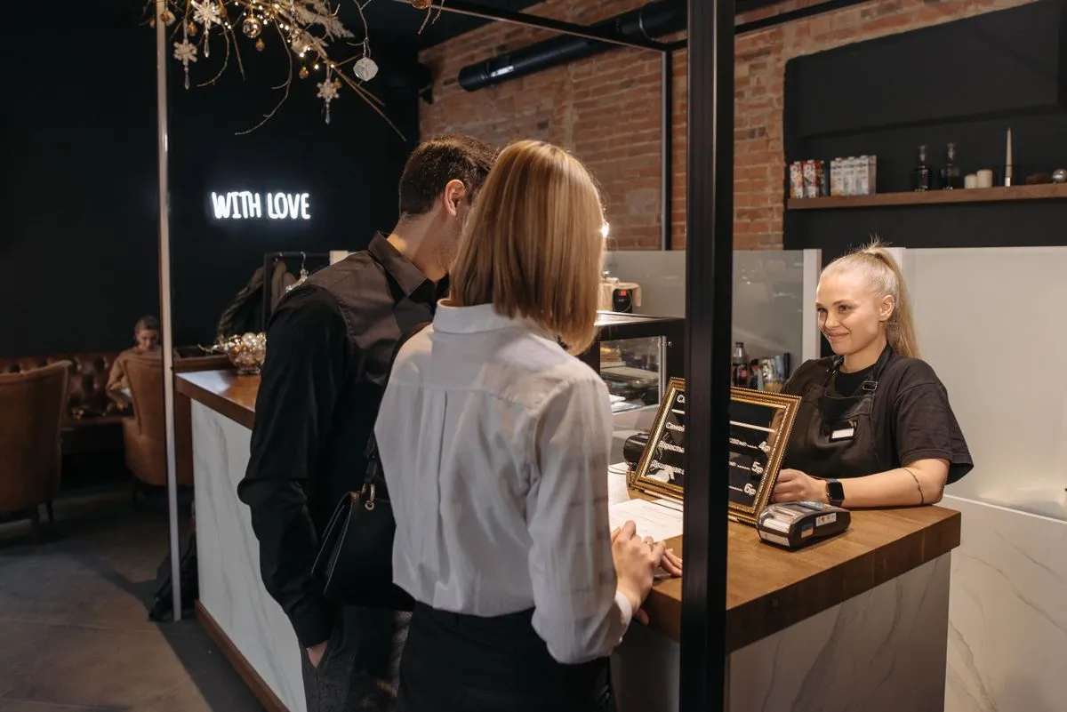 A shop owner smiling behind the counter